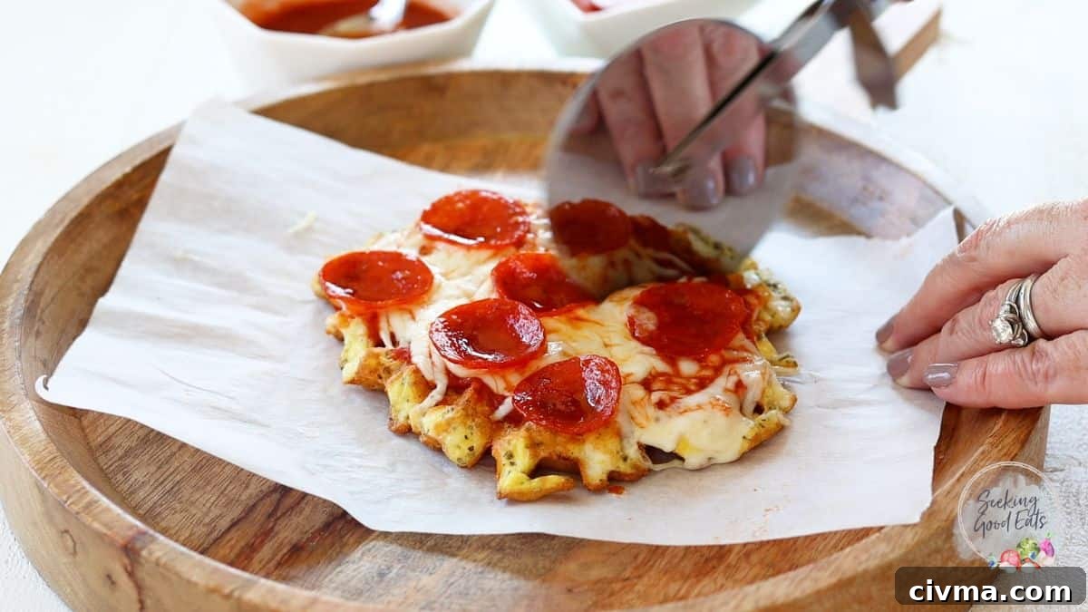 Slicing a cooked and cheesy pepperoni chaffle pizza.