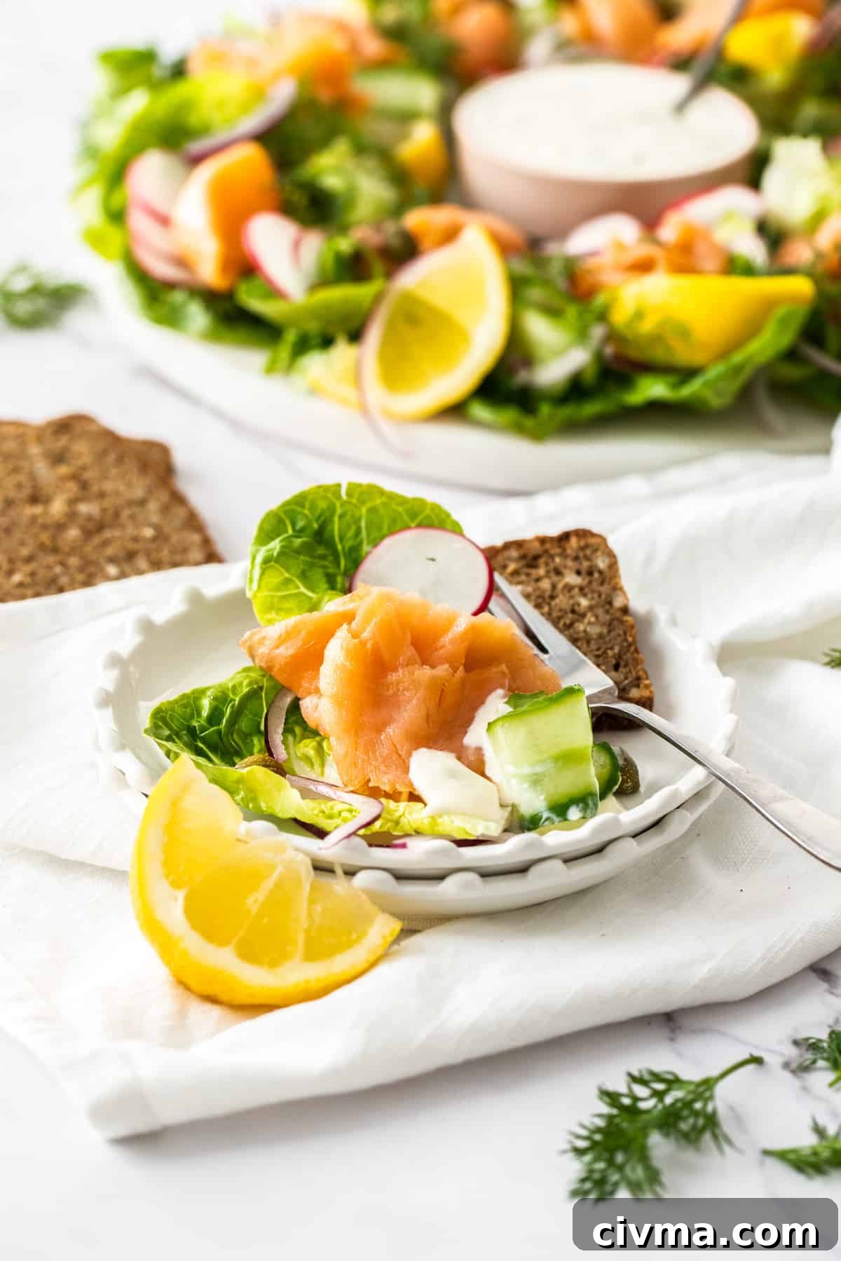 Serving of the smoked salmon wreath on a small round white plate.