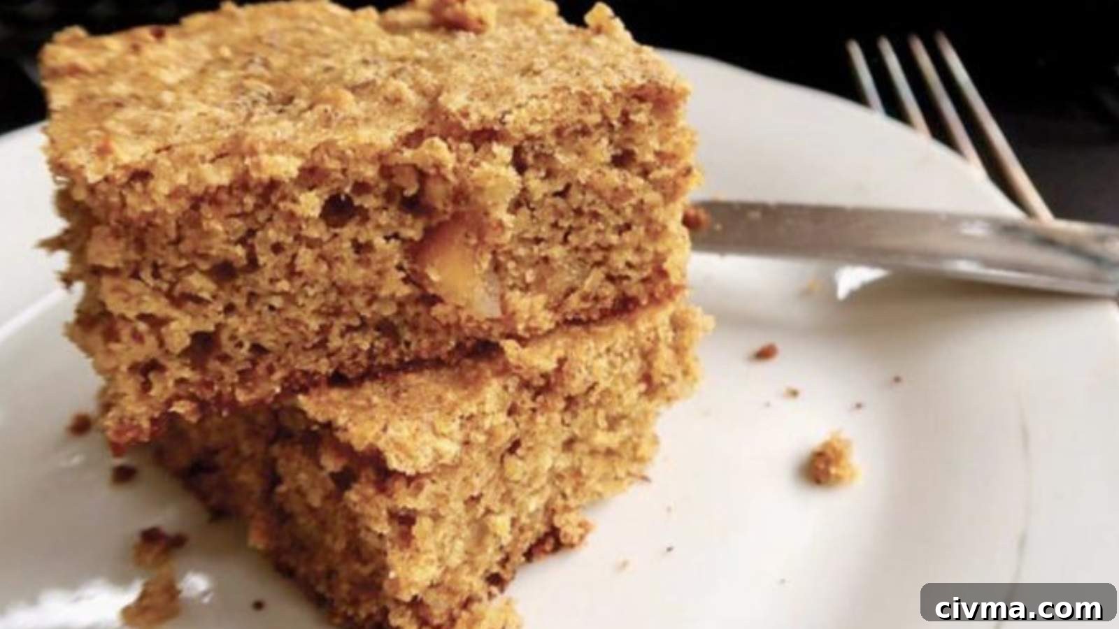 Two pieces of macadamia nut coffee cake on top of each other on a white plate.